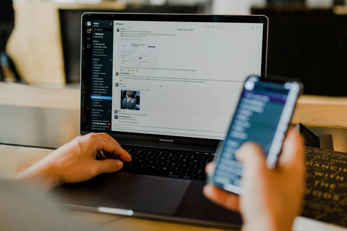 ノートPCとスマートフォンを操作する手元